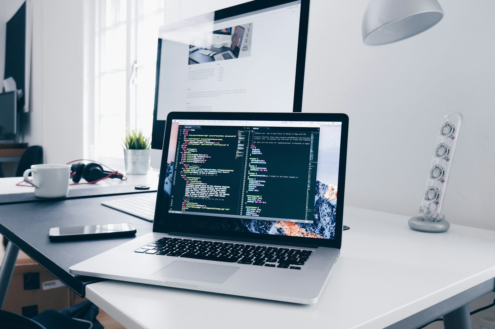 A developer's desk with a laptop and external display