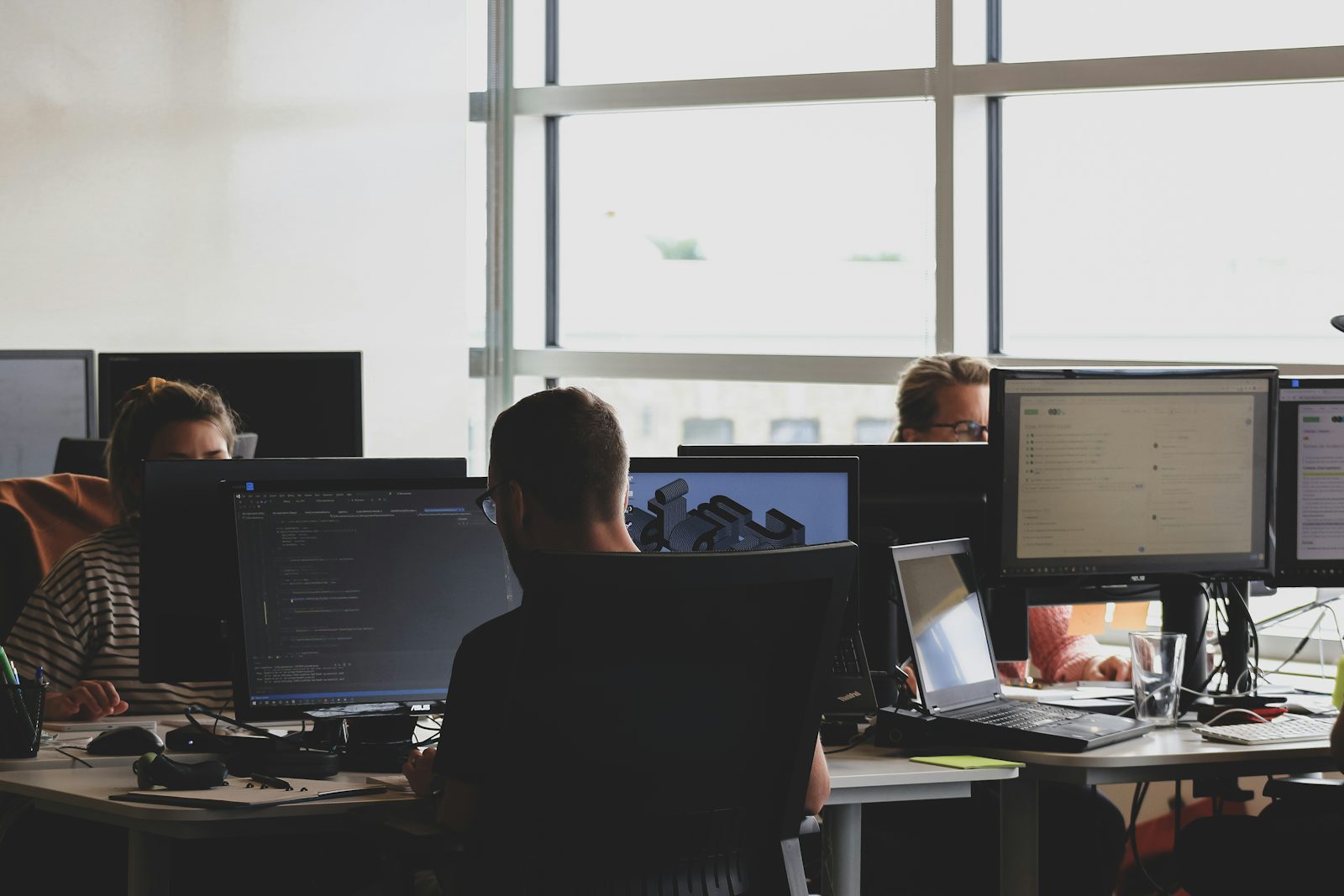 Developers working at a bank of monitors