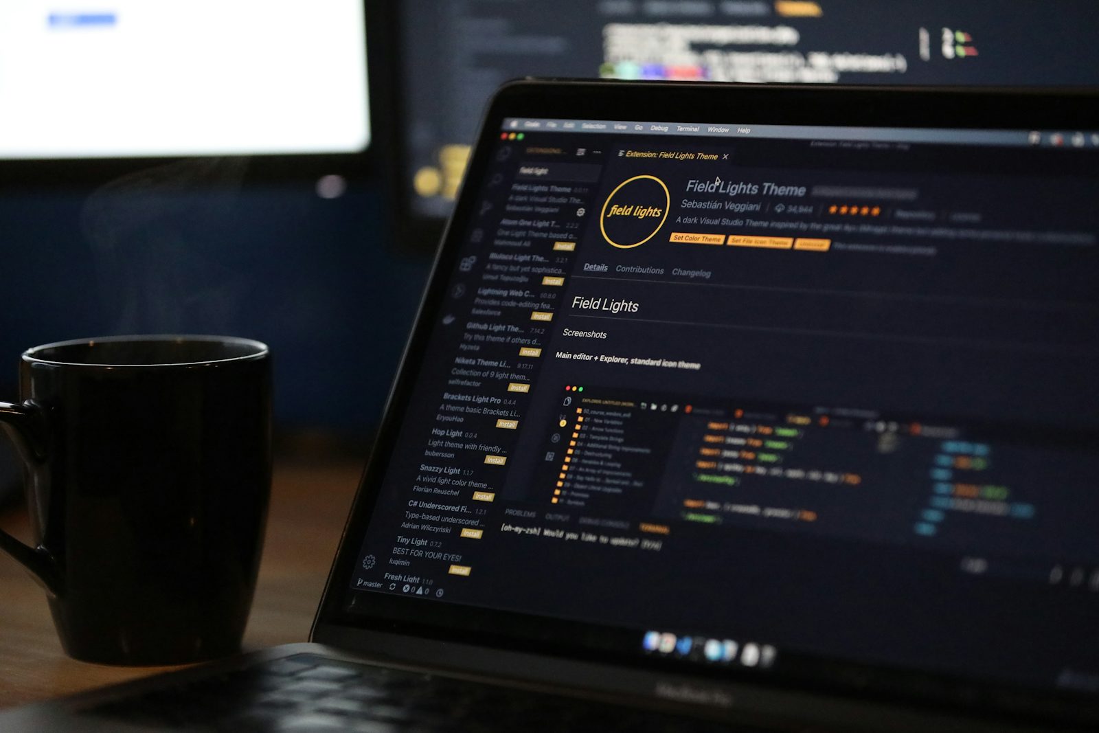 Laptop showing a code editor beside a coffee cup