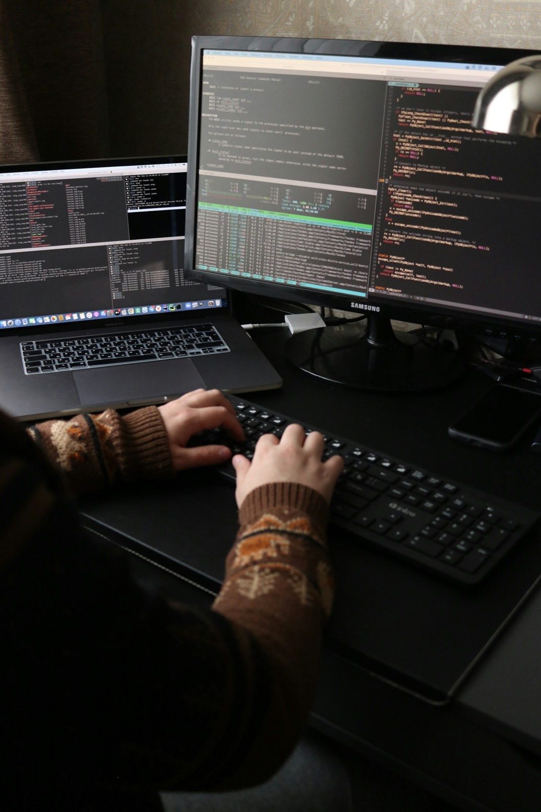 Hands typing at a keyboard in front of a monitor